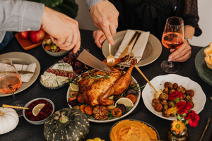 A Thanksgiving dinner table with a roasted chicken as the centerpiece.