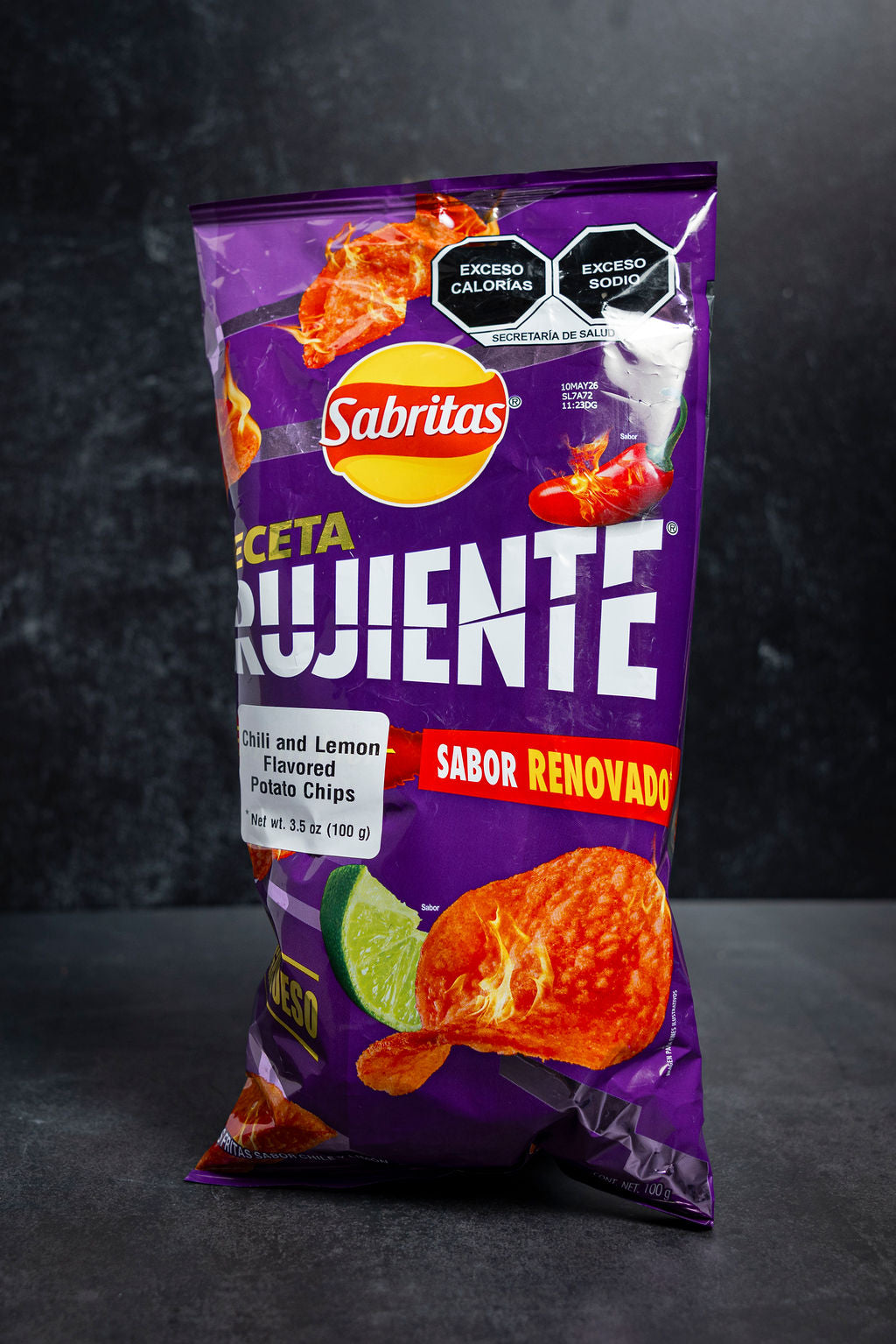 Purple Sabritas chip bag with orange chips on a dark background