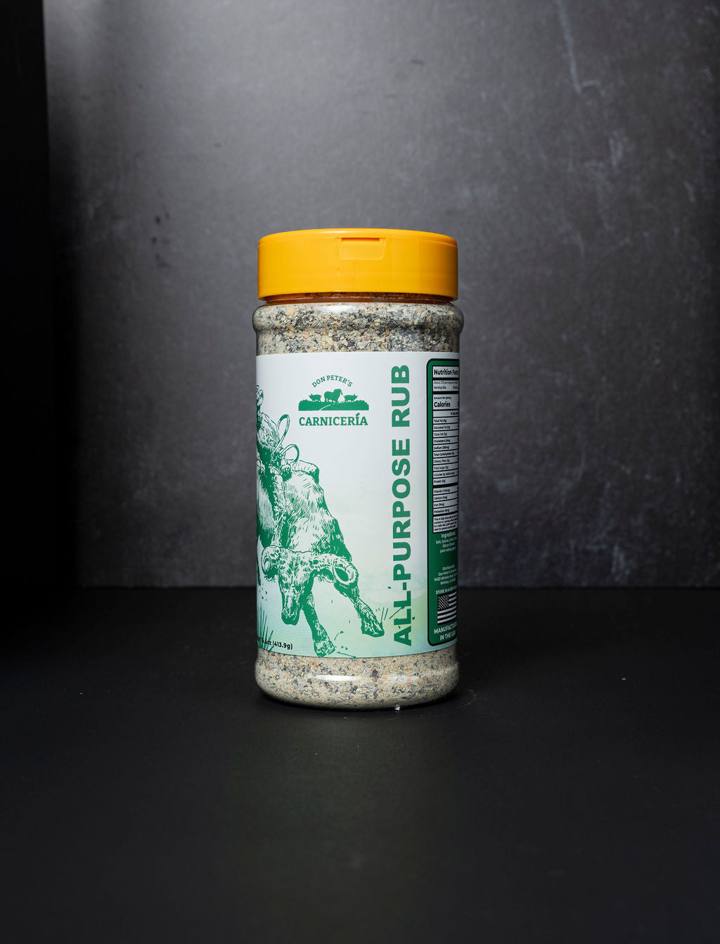 Jar of all-purpose rub with a yellow lid on a dark background