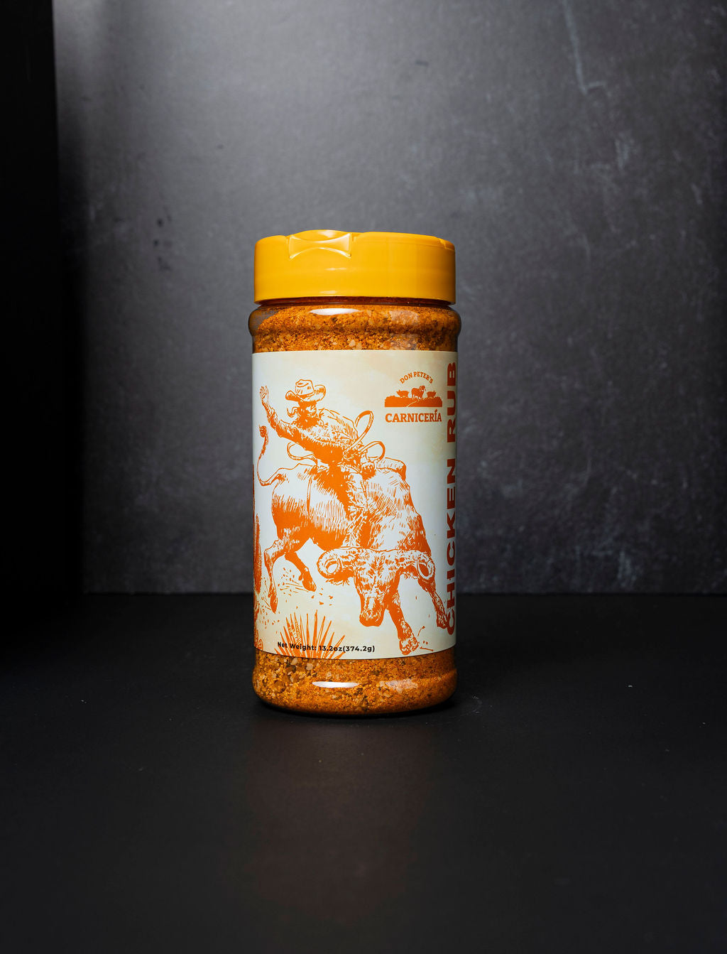 Spice jar with a yellow lid and bull design on a dark background